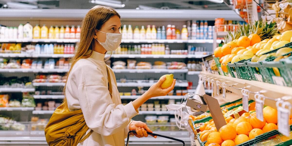 一个戴着口罩在杂货店购物的女人