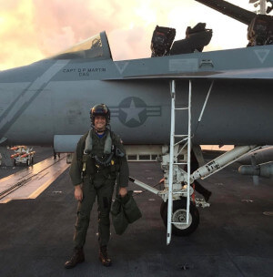 退役的美国海军飞行员Will Pressley站在战斗机旁